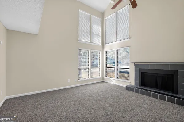 a view of an empty room with a fireplace and a window