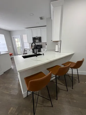 a kitchen with a dining table chairs and refrigerator