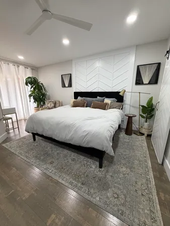a bedroom with a large bed and potted plant