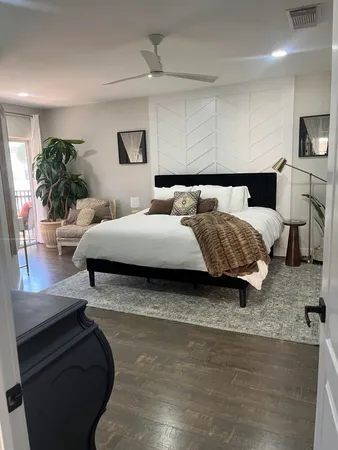 a living room with a bed furniture and a potted plant