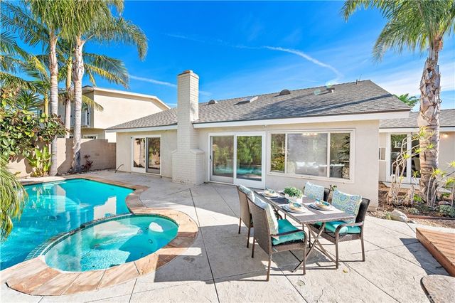 an aerial view of a house with swimming pool and outdoor seating