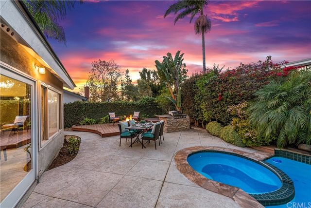 a view of a house with a yard plants and palm trees