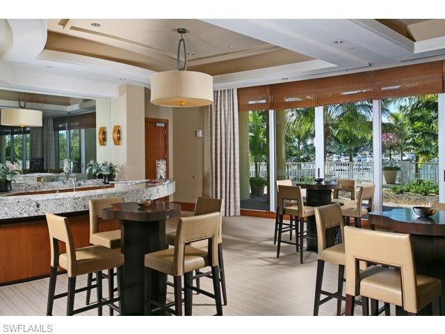 13675 Vanderbilt Drive, Unit 1107 Naples, FL 34110 - Photo 12 of 23 a dining room with furniture and a floor to ceiling window