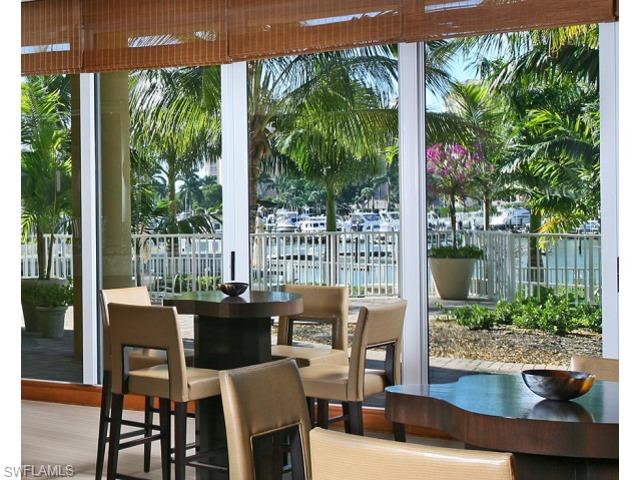 13675 Vanderbilt Drive, Unit 1107 Naples, FL 34110 - Photo 13 of 23 a dining room with furniture and garden view