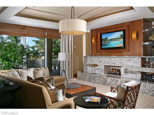 13675 Vanderbilt Drive, Unit 1107 Naples, FL 34110 - Photo 10 of 23 a living room with furniture a fireplace and a large window