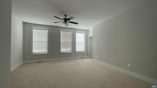 an empty room and chandelier fan