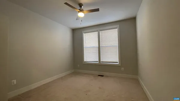 an empty room with closet and fan