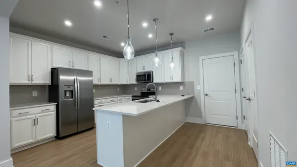 a kitchen with a sink a counter top space stainless steel appliances and cabinets