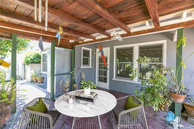 a view of a house with a yard and potted plants