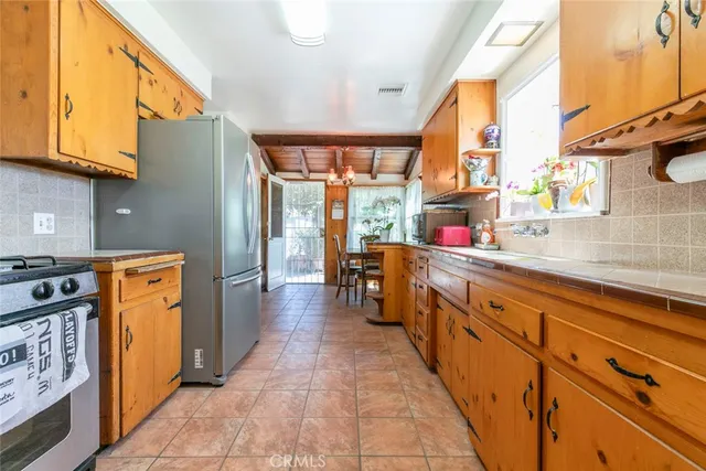 a large kitchen with stainless steel appliances granite countertop lots of counter top space and wooden floor