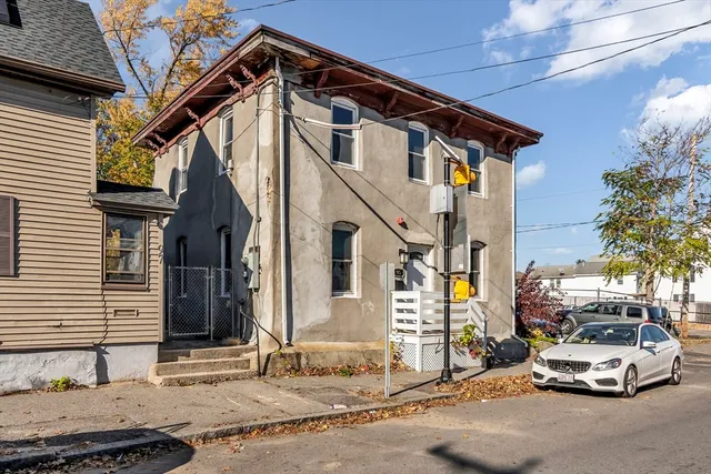 a car parked in front of a white house