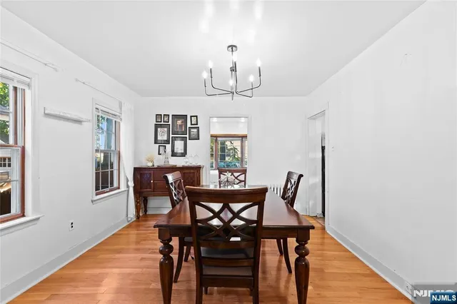 a view of a dining room with furniture a chandelier and wooden floor