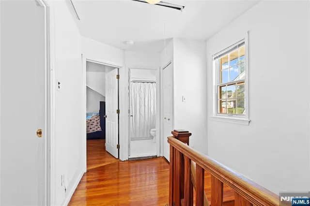 a view of hallway with stairs and wooden floor