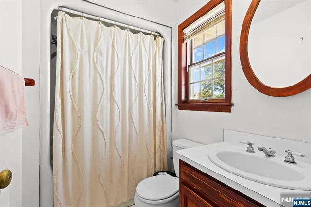 a bathroom with a sink vanity mirror and toilet