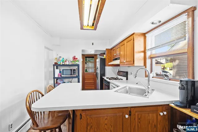 a kitchen with stainless steel appliances kitchen island granite countertop a sink a table and chairs