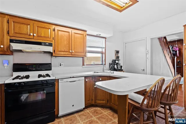 a kitchen that has a stove a table and chairs in it
