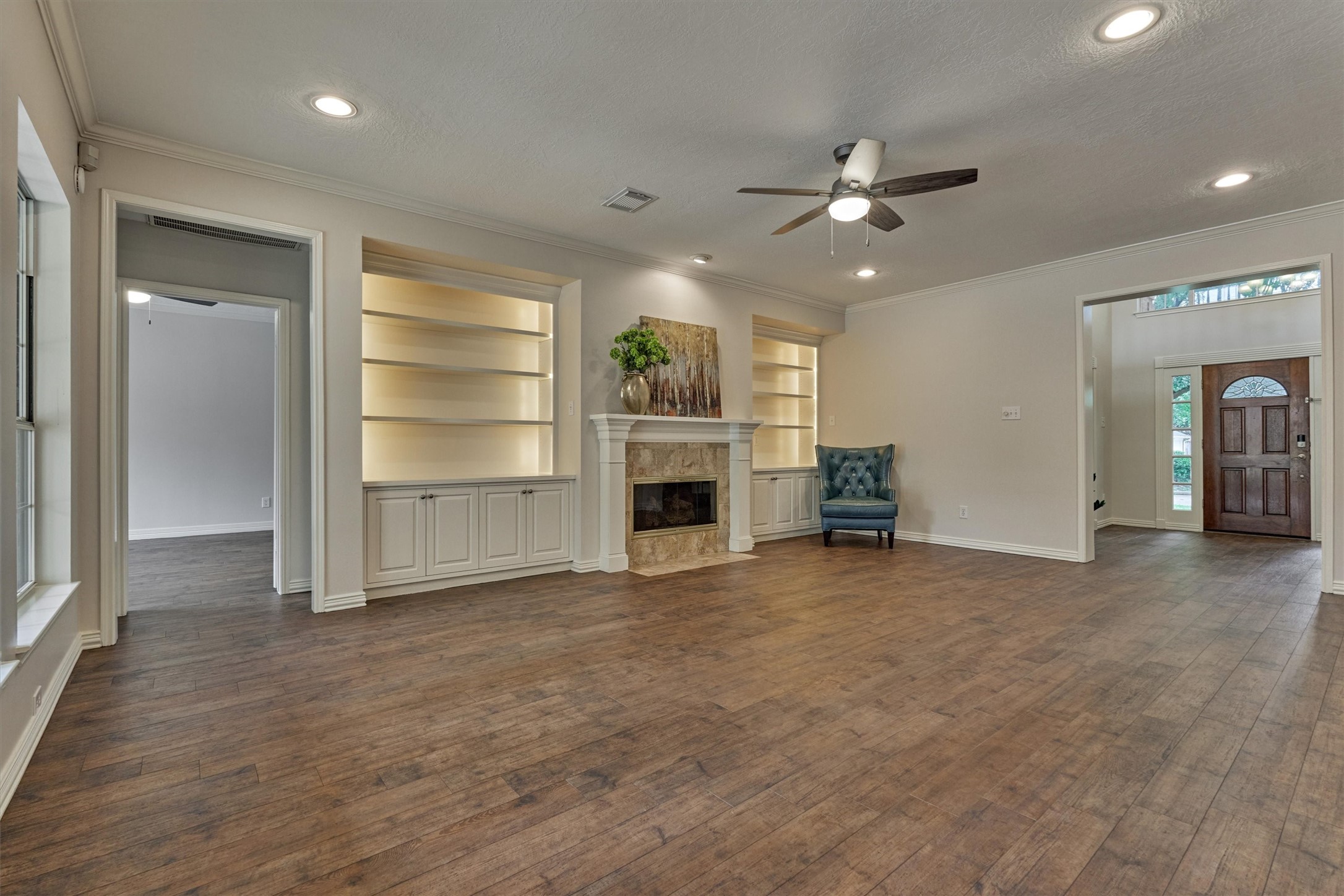 16707 Avenfield Road Tomball, TX 77377 - Photo 18 of 50 a view of a livingroom with a fireplace a ceiling fan a kitchen and entryway