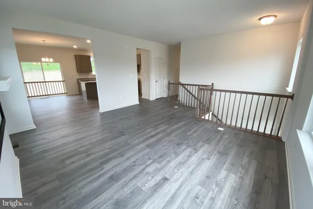 a view of a hallway with wooden floor and windows