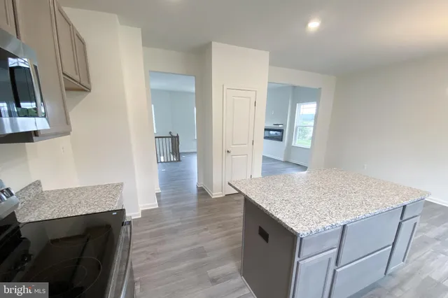 a kitchen with a sink a refrigerator and wooden floor