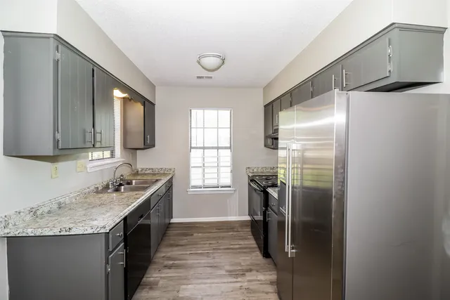 a kitchen with stainless steel appliances granite countertop a sink stove and refrigerator