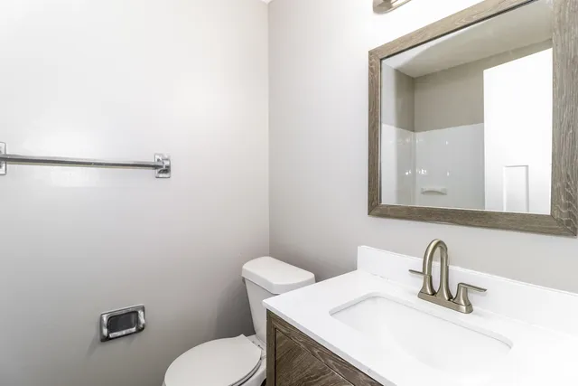a bathroom with a sink mirror and toilet