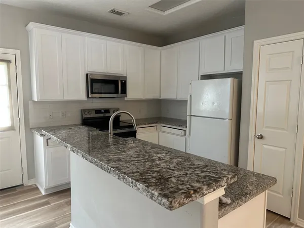 a kitchen with stainless steel appliances granite countertop a sink stove and refrigerator