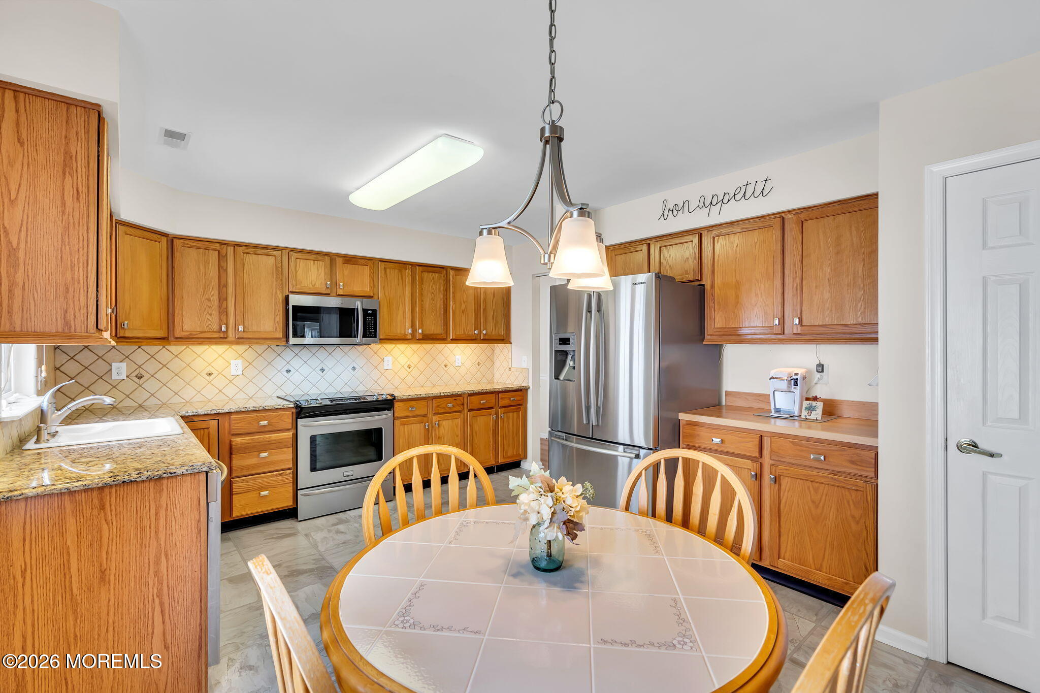 10 Congressional Road Jackson, NJ 08527 - Photo 20 of 72 a kitchen with stainless steel appliances granite countertop a sink a stove a refrigerator with a dining table and chairs