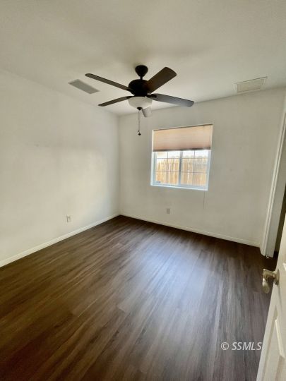 1304 South McCall Street Ridgecrest, CA 93555 - Photo 14 of 22 an empty room with wooden floor and windows
