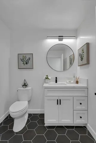 a bedroom with a bed painting on wall and a large window