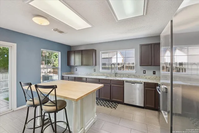 a kitchen with a table chairs sink and cabinets