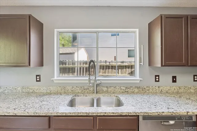 a kitchen with granite countertop a sink and a window