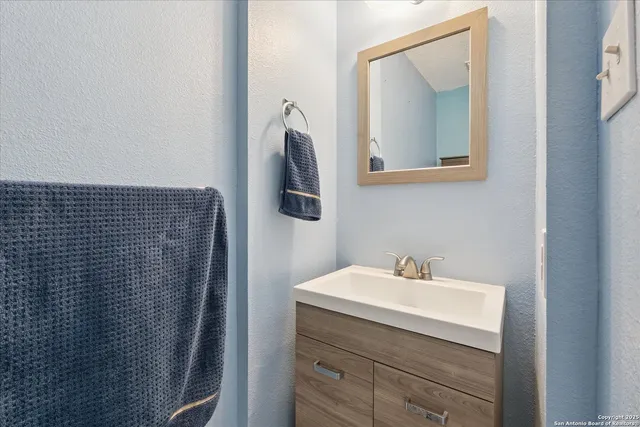 a bathroom with a sink vanity and mirror