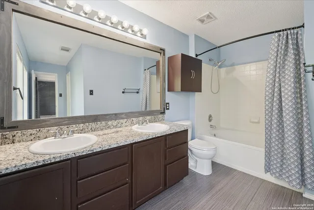 a bathroom with a granite countertop sink toilet and shower