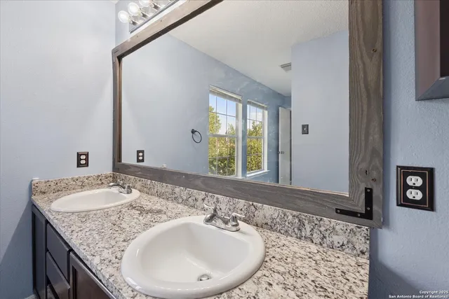 a bathroom with a granite countertop sink and a mirror