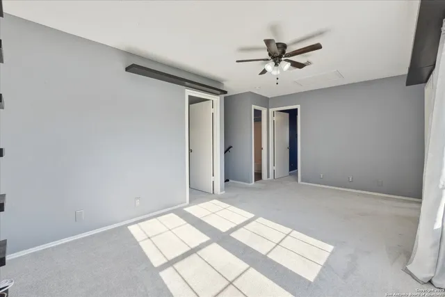 a view of a livingroom with a ceiling fan & window