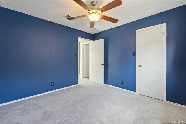 a view of an empty room with a ceiling fan