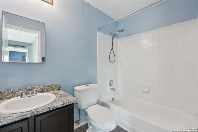 a bathroom with a granite countertop sink toilet and shower