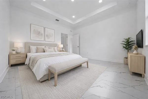 a bedroom with a bed and a potted plant on the dresser