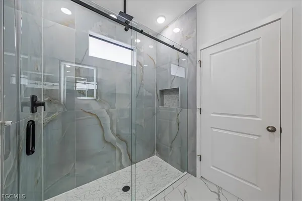a bathroom with a shower and a glass door