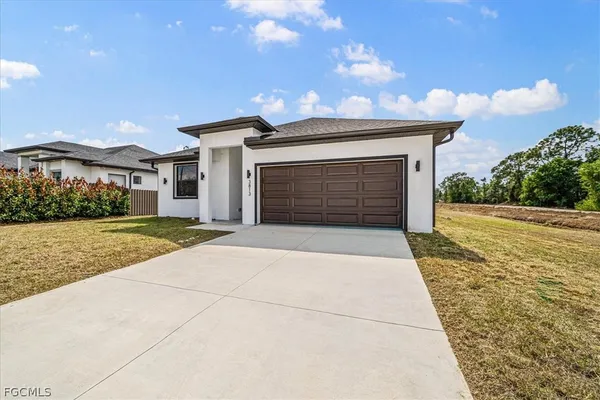 a front view of a house with a yard and garage