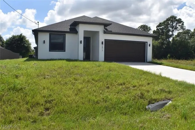 a front view of house with yard and garage
