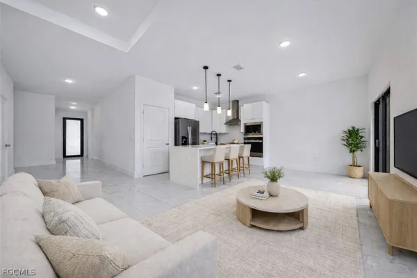 a living room with furniture and view of kitchen