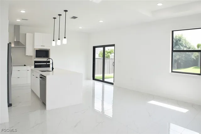 a kitchen with stainless steel appliances kitchen island wooden cabinets and window