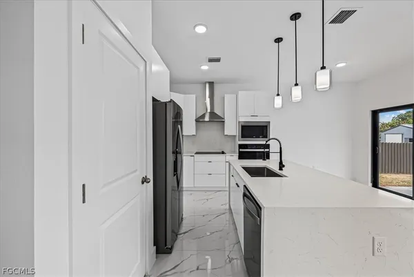 a kitchen with a refrigerator a stove and a sink