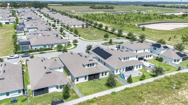 an aerial view of residential houses with outdoor space and swimming pool