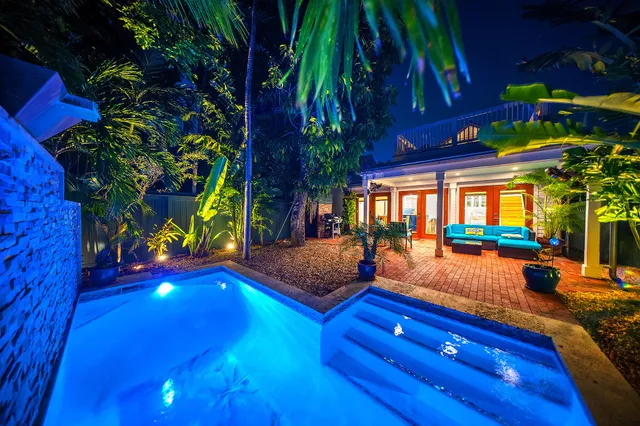 a backyard of a house with wooden floor and outdoor seating