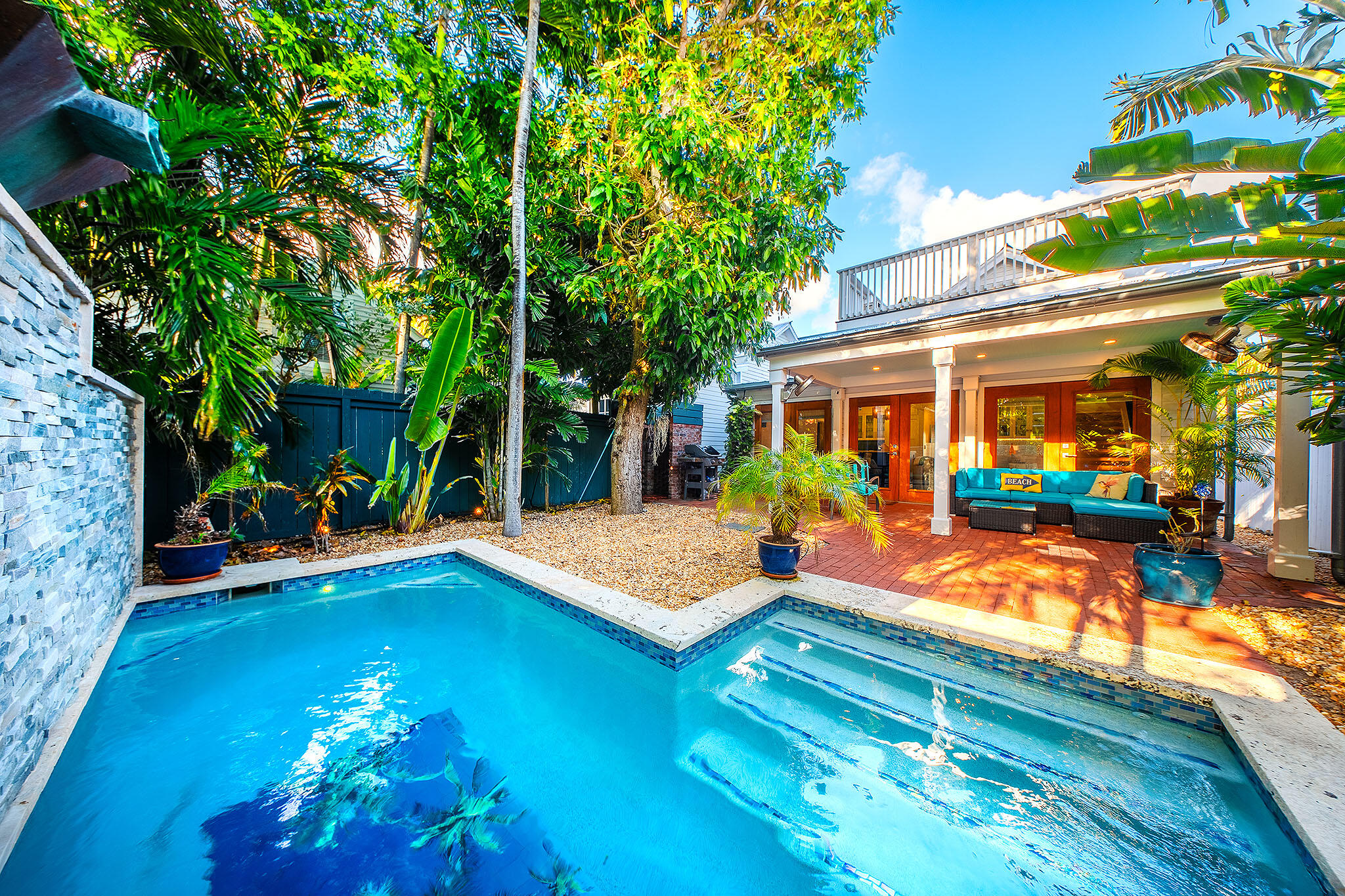 1116 Packer Street Key West, FL 33040 - Photo 27 of 57 a view of a patio with table and chairs potted plants and large tree