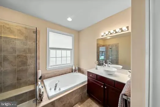 a bathroom with a bathtub a sink and a mirror