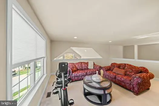 a view of a livingroom with furniture a fireplace and windows
