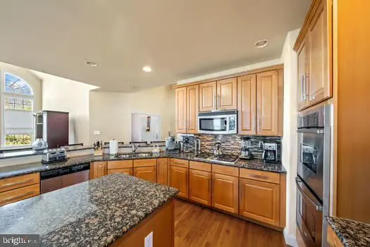 a kitchen with stainless steel appliances granite countertop sink stove and refrigerator